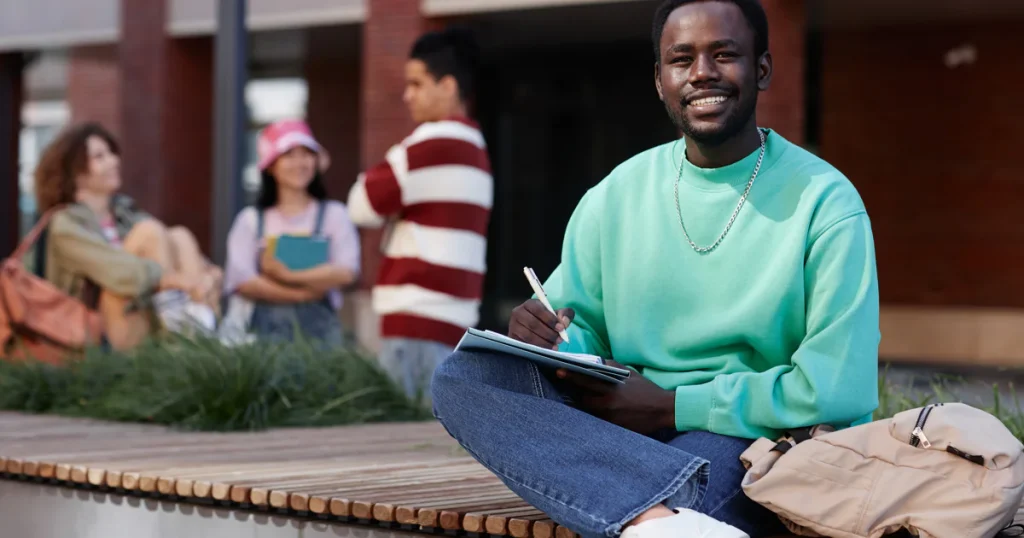 young-black-man-as-student-doing-homework-outdoors
